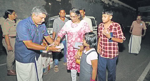 A man distributing sweets in Aranmula following the arrest of A Padmakumar.