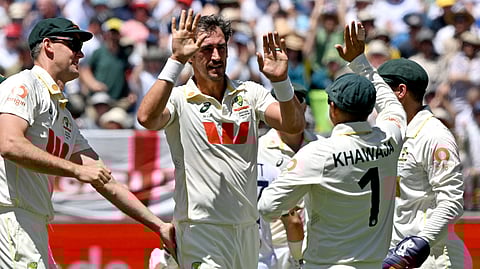 Australia’s Mitchell Starc (C) celebrates with teammates after taking the wicket of England’s Ben Duckett on day 1 of the first Ashes cricket Test match between Australia and England at Perth Stadium in Perth on November 21, 2025.