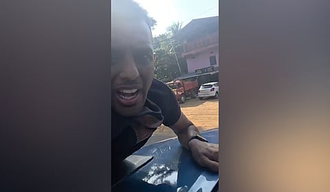 Car owner Solomon clinging onto the bonnet of the car.