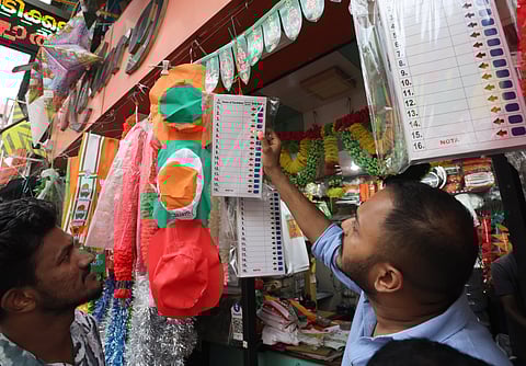 A youngster checks a mock ballot machine display to educate voters at a shop selling election merchandise.