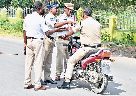 Police imposing challan on police personnel driving without helmet in Sangareddy on Monday