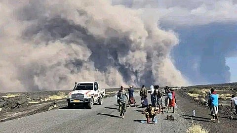 People watch ash billow from an eruption of the long-dormant Hayli Gubbi Volcano in Ethiopia's Afar region.