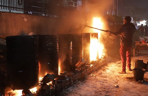 Woker melting bitumen to repair road.