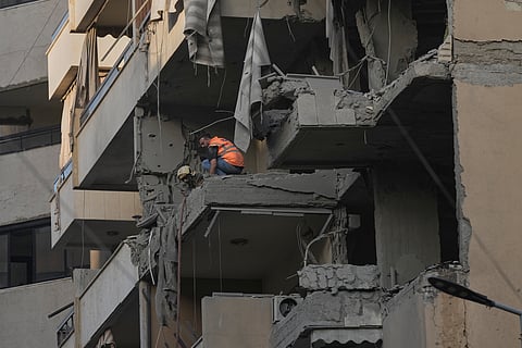 Civil defense workers inspect the damage at an apartment building hit during an Israeli airstrike on Dahiyeh in the southern suburb of Beirut, Sunday Nov. 23, 2025.