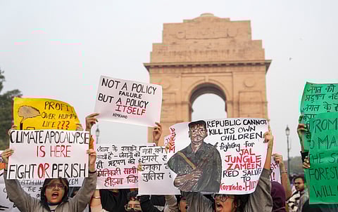 People raise slogans during a protest against worsening air quality in the national capital, at the India Gate, in New Delhi, Sunday, Nov. 23, 2025.