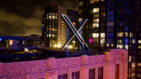 Workers install lighting on an “X” sign atop the company headquarters in downtown San Francisco, July 28, 2023.