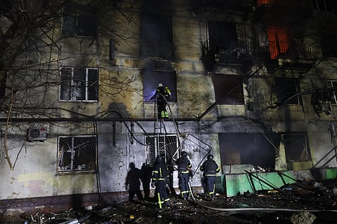 Rescue workers try to put out a fire of residential building burning after a Russian attack on Zaporizhzhia, Ukraine, Wednesday, Nov. 26, 2025.