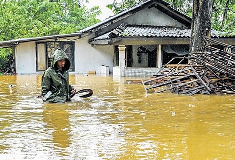 A man wades through floodwater outside his house following heavy rainfall in Kaduwela on the outskirts of Colombo on Friday.