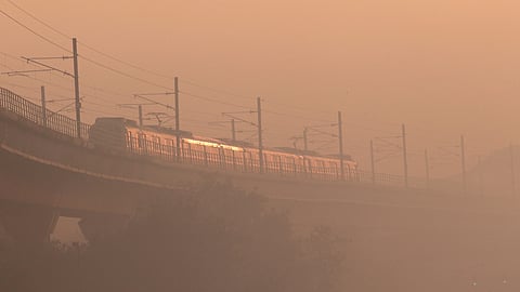 A Delhi Metro train passes as dense smog engulfs the elevated track in New Delhi on Friday, Nov 28, 2025.