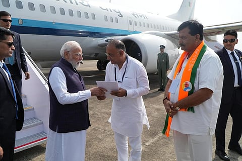 Health and family welfare minister Dinesh Gundu Rao handing over the CM's memorandum to PM Narendra Modi at Mangaluru International Airport on Friday morning.