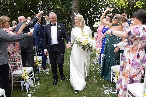 Australian Prime Minister Anthony Albanese, center left, and Jodie Haydon, center right, are showered with confetti after getting married in Canberra, Saturday, Nov 29, 2025.