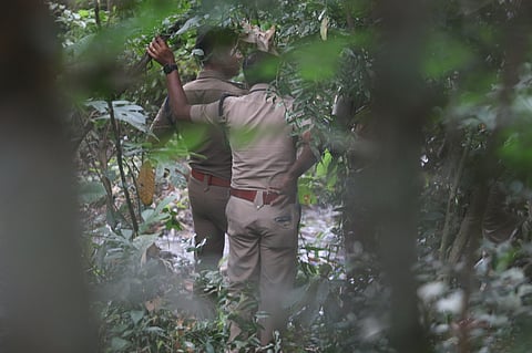 Police team conducting an inquest of the mortal remains recovered from a forested area in Kalamassery.