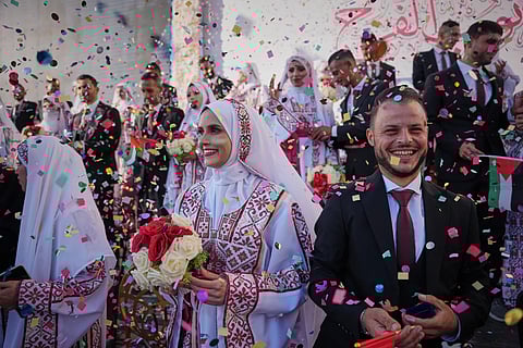 Palestinian couples participate in a mass wedding ceremony in Hamad City in Khan Younis, Gaza Strip, Tuesday, Dec. 2, 2025.