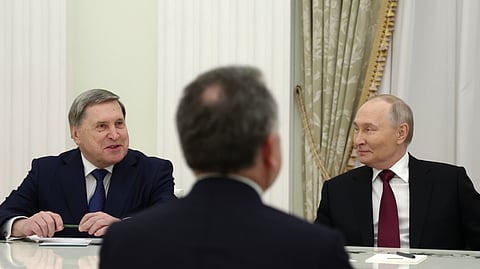 Russian President Vladimir Putin, right, and Russian presidential foreign policy adviser Yuri Ushakov, left, attend talks with US special envoy Steve Witkoff, back to a camera, at the Senate Palace of the Kremlin in Moscow, Russia, Tuesday, Dec. 2, 2025.