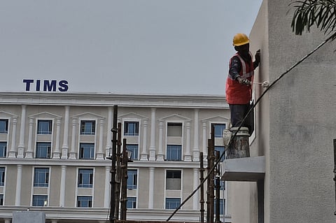 A worker paints the entrance of the Telangana Institute of Medical Sciences in at Sanath Nagar in Hyderabad.