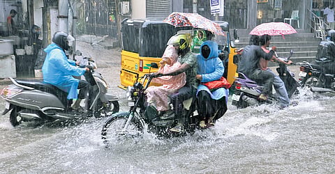 People seen on the rain and flood at Thana street in Purasaiwalkam on Thursday.