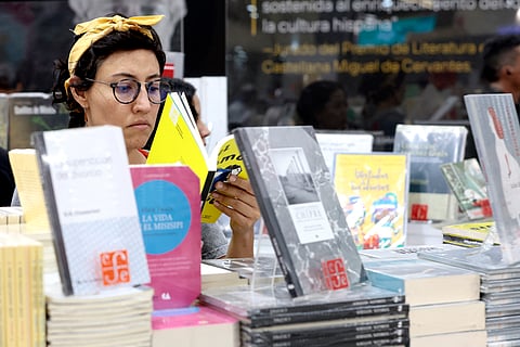 A woman reads at the Guadalajara International Book Fair on November 29, 2025, in Guadalajara