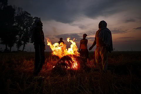 Farmers warm themselves around burning stubble on a winter morning during sunrise near the India-Pakistan International border, at Ranbir Singh Pura, in Jammu district, Friday, Dec. 5, 2025.
