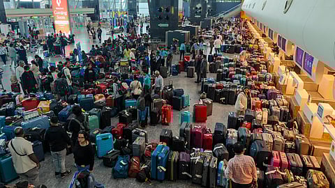 Stranded passengers search for their luggage near a counter after IndiGo cancelled more than 400 flights, at the Kempegowda International Airport, in Bengaluru, Karnataka, Friday, Dec. 5, 2025.