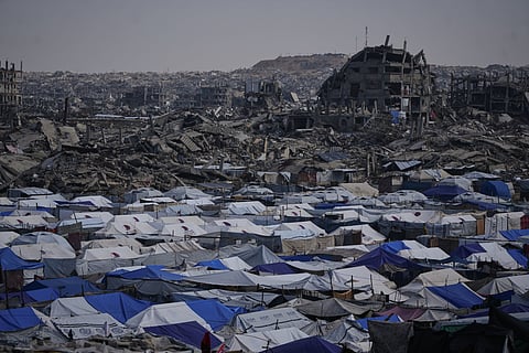 Tents sheltering displaced Palestinians stand amid the destruction left by the Israeli air and ground offensive in Gaza City Friday, Dec. 5, 2025.