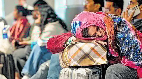 A passenger rests while waiting at Terminal 1 of the Indira Gandhi International Airport for her flight in New Delhi on Saturday.