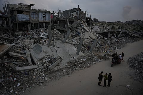 Palestinians stand on a street in Jabaliya, northern Gaza Strip, Saturday, Dec. 6, 2025.