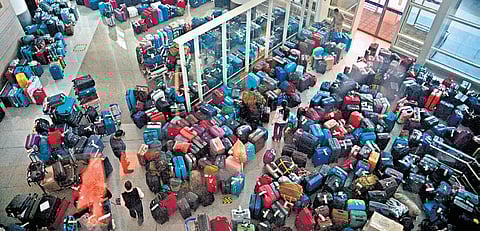 Passengers looking for their bags in the massive buildup of unclaimed luggage at IGI Airport on Sunday
