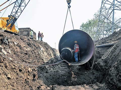 Workers installing huge pipelines with a crane as they involve in the construction activity the seed access road at Rayapudi in Amaravati on Monday