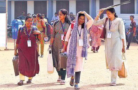 Election officials after collecting the polling materials from the control centre move towards their designated polling booths