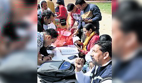 BLOs helping voters fill their enumeration forms.
