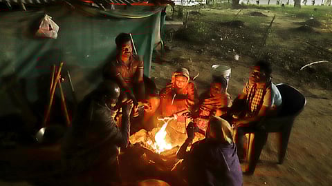 Cold weather grips Bhubaneswar, labourers huddle around bonfires to keep themselves warm on Monday.