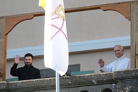 Ukraine's President Volodymyr Zelenskyy and Pope Leo XIV wave to journalists during their meeting in Castel Gandolfo, Italy, Tuesday, Dec. 9, 2025.