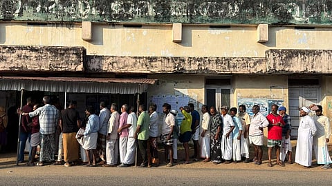 Voters queue up at a polling booth in Perumathura coastal village in Thiruvananthapuram for local body election on December 9, 2025.