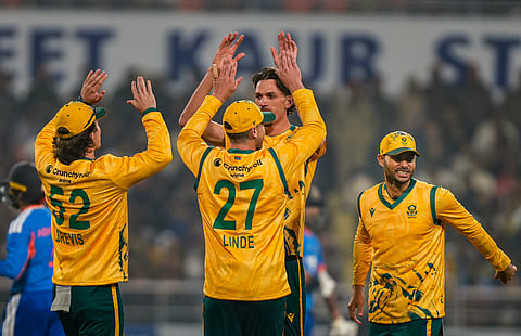 South Africa's Marco Jansen, back center, celebrates with teammates after taking the wicket of India's Abhishek Sharma during the second T20 International at Maharaja Yadavindra Singh International Cricket Stadium in New Chandigarh. (Photo | PTI)