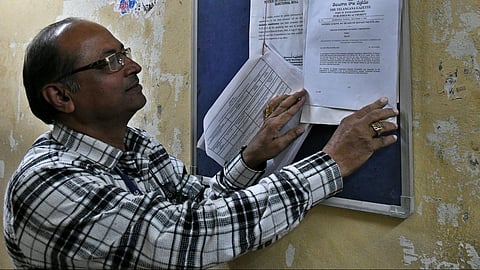 A staffer puts up a notice related to ward delimitation in Hyderabad on Wednesday