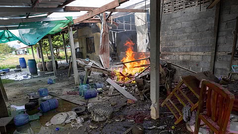 Flame rises from a house that, Thai local security forces say, was damaged by a Cambodian artillery strike in Surin province, Thailand, Thursday, Dec. 11, 2025.