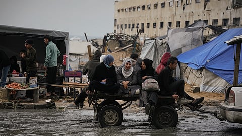 Palestinians ride in a cart pulled by a vehicle through a flooded street after stormy weather in Gaza City on Wednesday, Dec. 10, 2025.