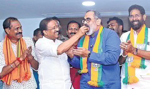 BJP leader V Muraleedharan shares sweets with state president Rajeev Chandrasekhar after declaration of election results at Mararji Bhavan, Thiruvananthapuram.