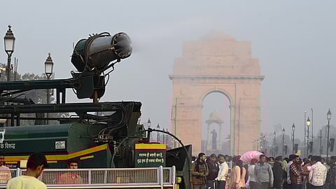 An anti-smog gun sprays water to settle dust particles near India Gate amid smoggy conditions in New Delhi, on December 12, 2025.