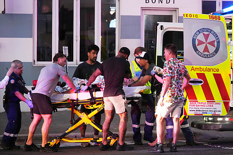 Emergency workers transport a person on a stretcher after a reported shooting at Bondi Beach in Sydney, Sunday, Dec. 14, 2025.