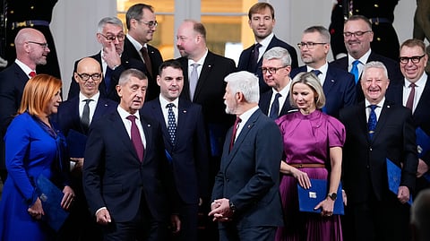 Czech Republic's President Petr Pavel, center, and Prime Minister Andrej Babis, center left, pose for a family photo with newly appointed government members at the Prague Castle in Prague, Czech Republic, Monday, Dec. 15, 2025.