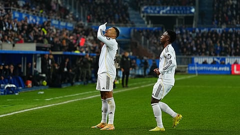 Real Madrid's Kylian Mbappe, left, celebrates with Real Madrid's Vinicius Junior after scoring the opening goal during the Spanish La Liga soccer match between Alaves and Real Madrid in Vitoria-Gasteiz, Spain, Sunday, Dec. 14, 2025.