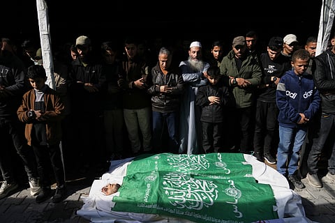 Palestinians carry the body of a Hamas militant draped in the group's flag, who was killed in an Israeli army strike, during his funeral in Gaza City, Sunday, Dec. 14, 2025.