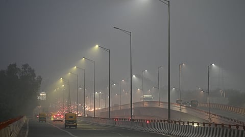 Vehicles move on a road amid low visibility due to a layer of smog, near Sarai Kale Khan Sunday Evening in New Delhi, Sunday, Dec. 14, 2025.