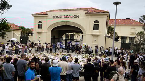 People gather at a floral tribute outside Bondi Pavilion at Bondi Beach on Tuesday, Dec. 16, 2025, following Sunday's shooting in Sydney, Australia.