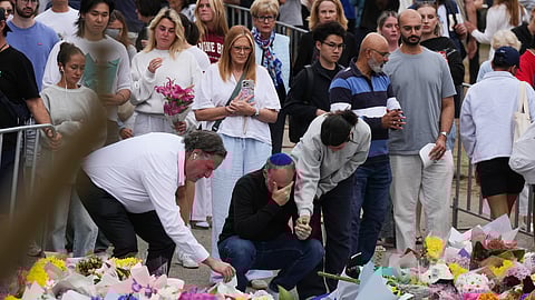 People weep and offer flowers at a floral memorial for victims of Sunday's shooting at the Bondi Pavilion at Bondi Beach on Tuesday, Dec. 16, 2025, in Sydney, Australia.