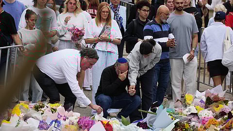 People weep and offer flowers at a floral memorial for victims of Sunday's shooting at the Bondi Pavilion at Bondi Beach on Tuesday, Dec. 16, 2025, in Sydney, Australia.