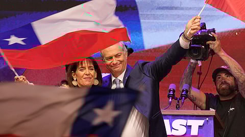 Chilean presidential candidate Jose Antonio Kast, of the opposition Republican Party, and his wife, Maria Pia Adriasola, wave flags after winning the presidential runoff election in Santiago, Chile, Sunday, Dec. 14, 2025.