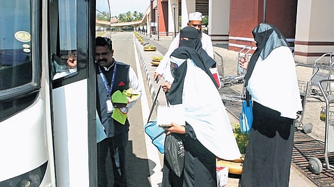 Passengers, who returned after performing Umrah, move towards a bus for their further journey to Kozhikode, after the Air India Express flight from Jeddah was diverted and made an emergency landing at Kochi airport on Thursday.