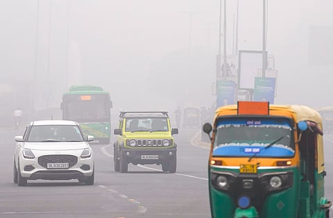 Vehicles ply on road on a foggy winter morning, in New Delhi, Thursday, Dec. 18, 2025.